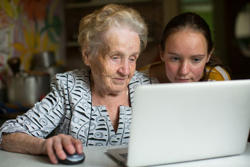 en äldre kvinnor sitter framför en dator